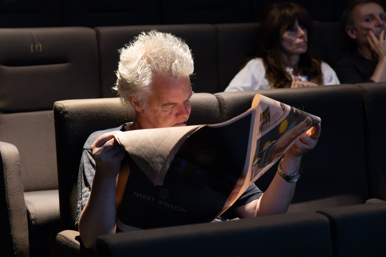 A man reading in a cinema